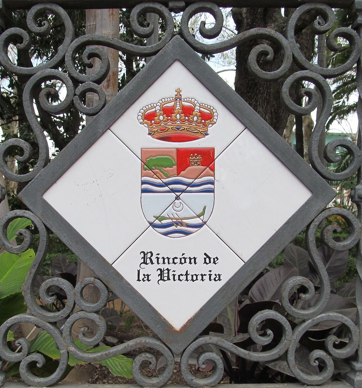 Diamond-shaped sign with crown and coat of arms, featuring "Rincón de la Victoria" text.